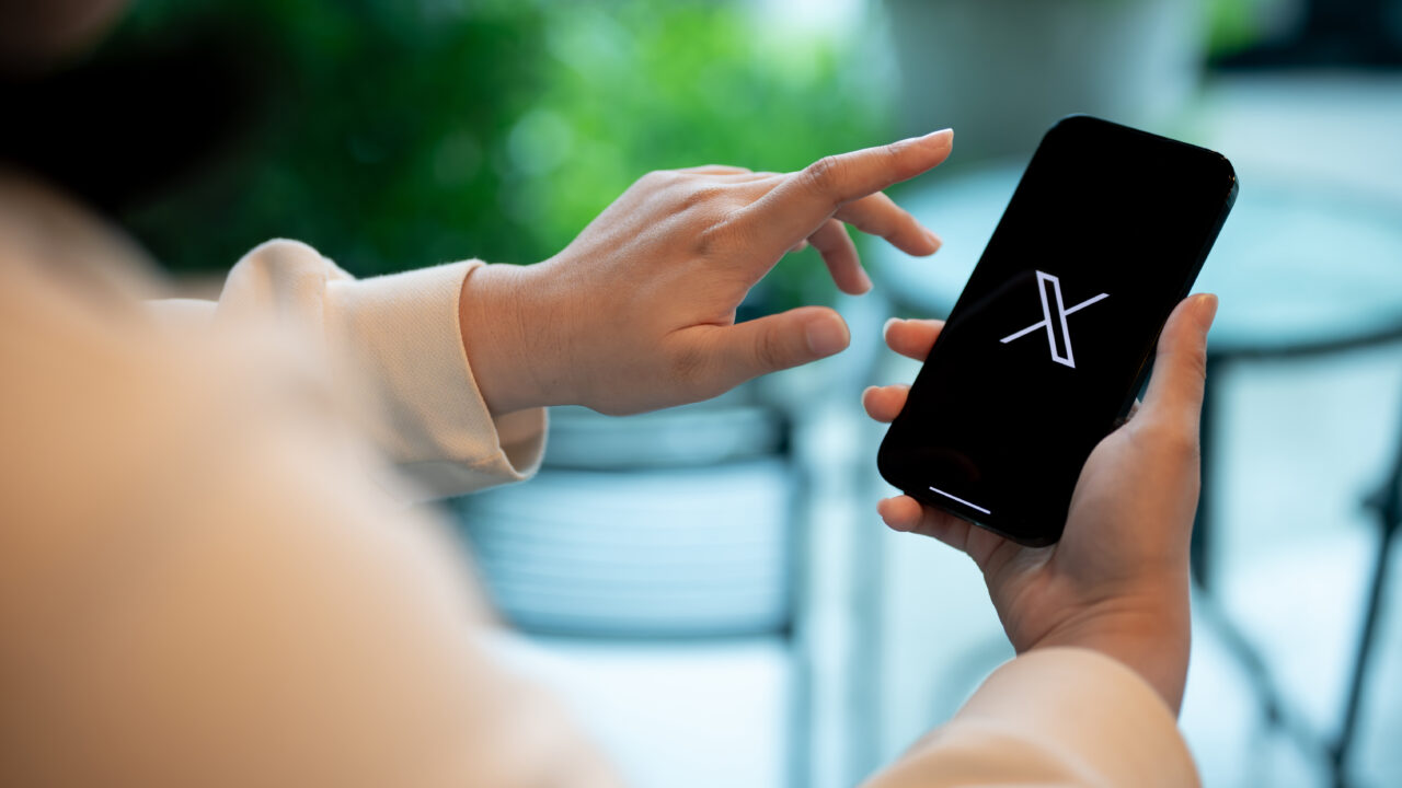 Person on phone scrolling X using it as a B2B thought leadership platform - Dig & Dig