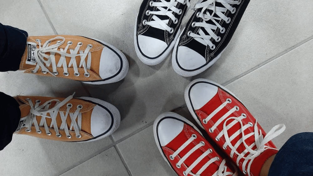 Group of 3 gen z friends taking picture of their shoes wearing the same brand - Dig & Dig
