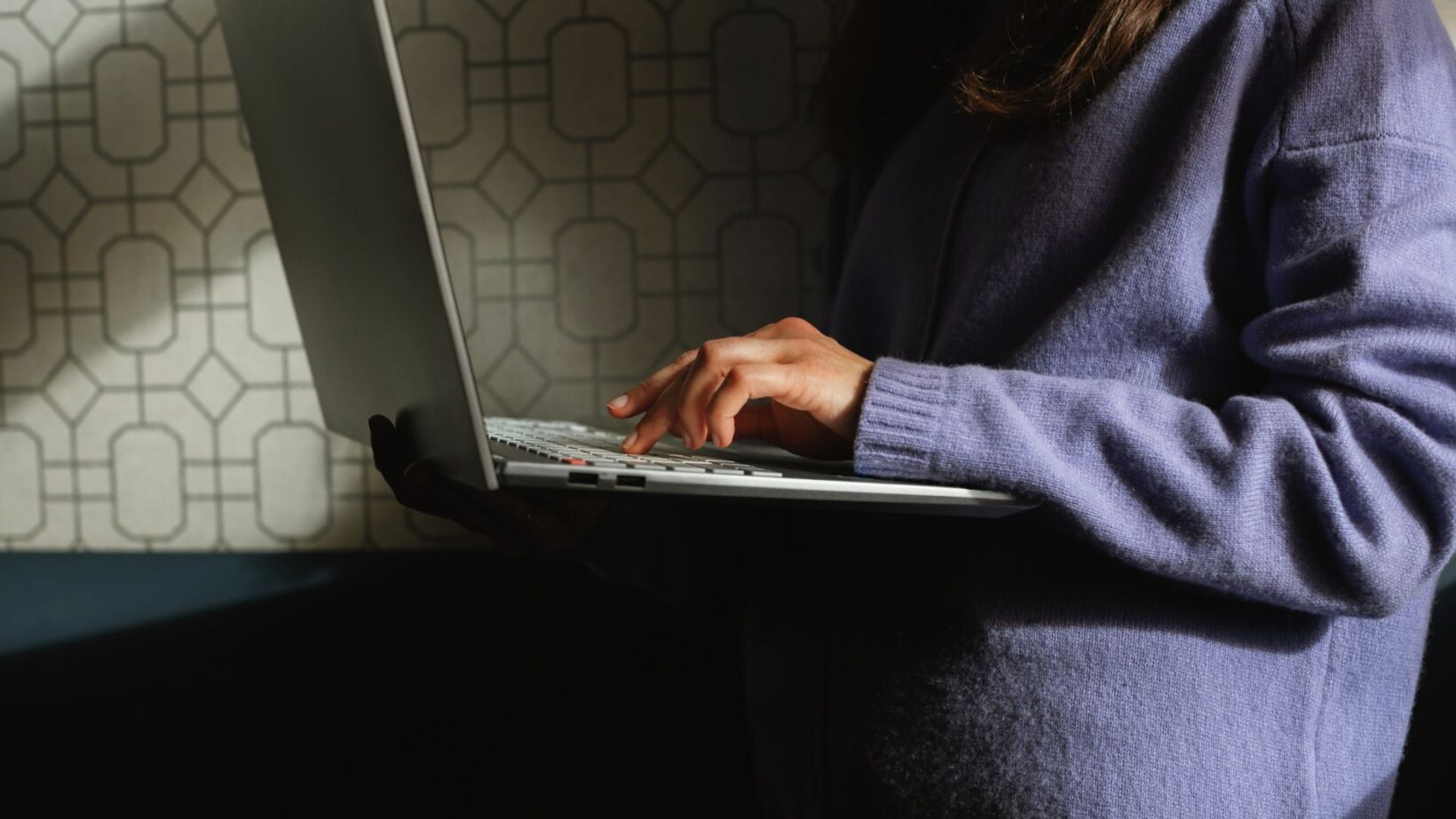 Person on laptop researching how AI search engines choose brands to mention in search results - Dig & Dig
