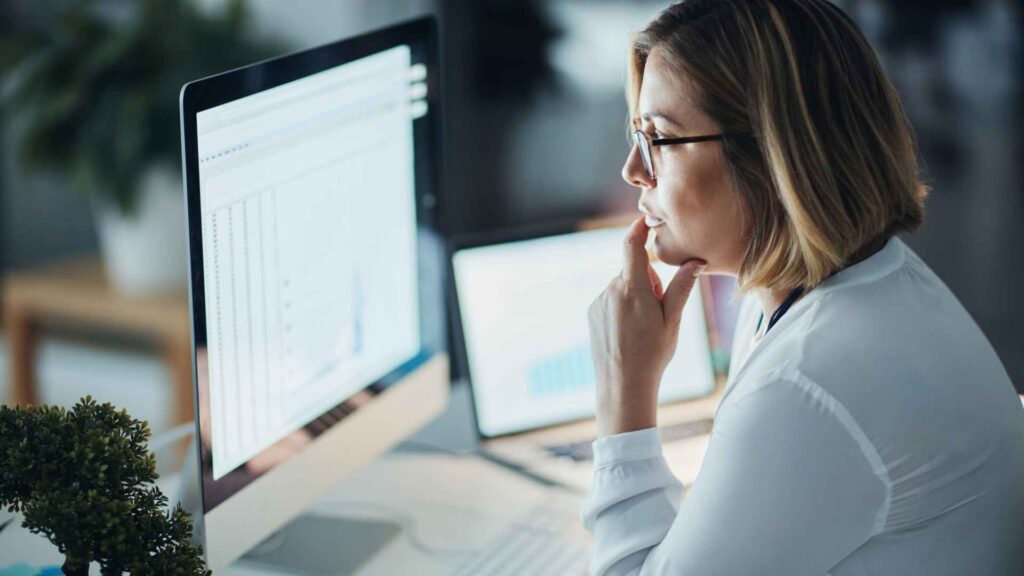 Woman on computer in dark looking at Google algorithm updates - Dig & Dig