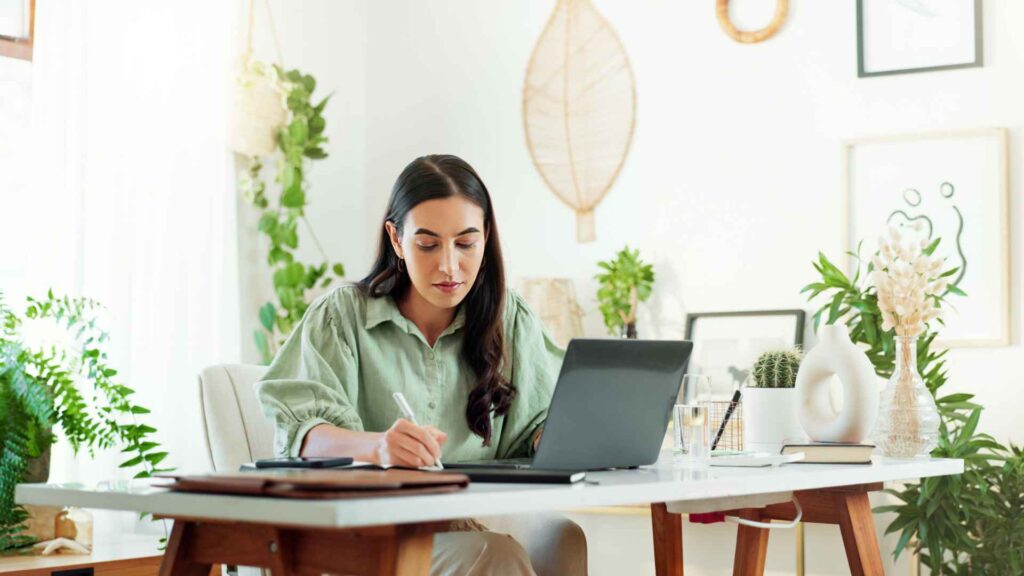 Young woman sitting at desk surrounded by plants looking at SEO ranking - Dig & Dig