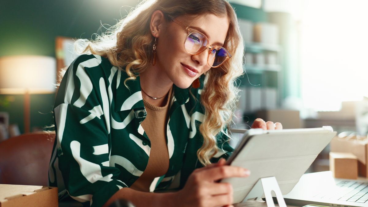 Woman with blonde curly hair scrolling black friday AI shopping optimization deals on a tablet - Dig & Dig